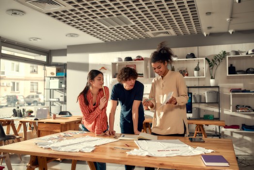 Three people looking at a sheet of paper