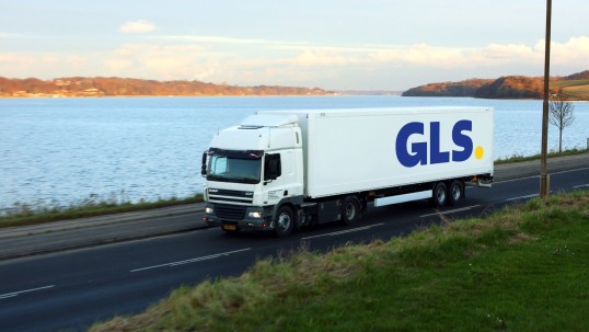 A GLS truck drives by the water