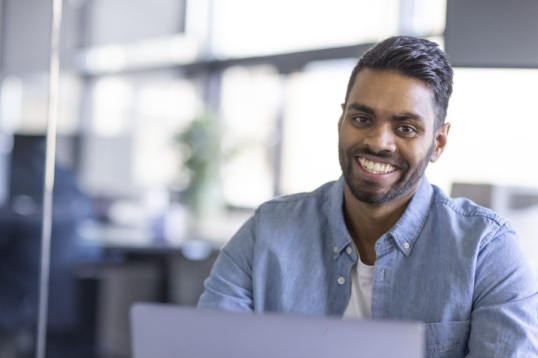 Smiling GLS employee using a laptop