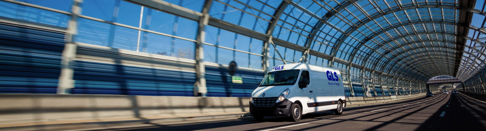 Een camionnette rijdt binnen een glazen tunnel