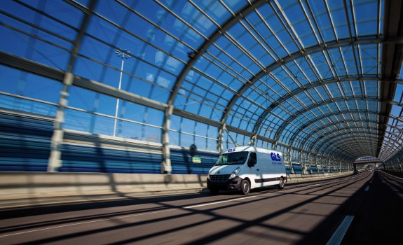Een camionnette rijdt binnen een glazen tunnel
