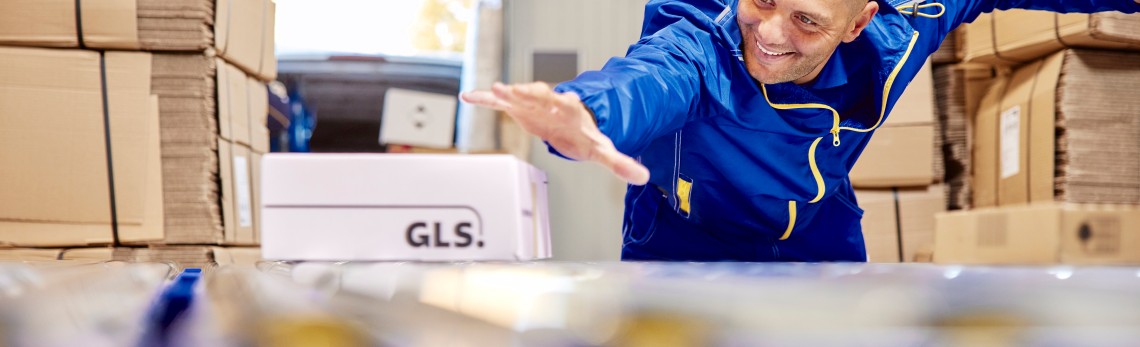 GLS-kuljettaja luovuttaa paketin asiakkaalle ovella