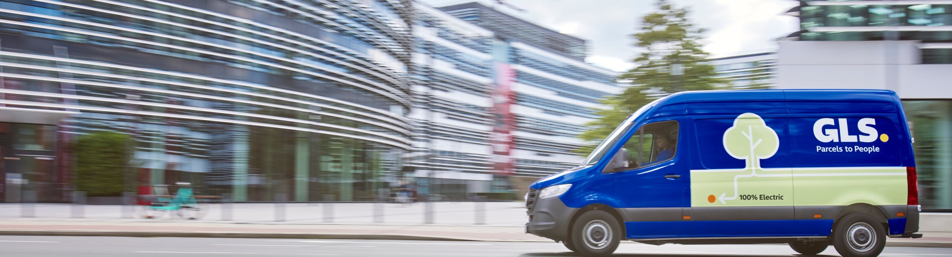 GLS sinisen värinen 100% sähköauto ajaa kadulla