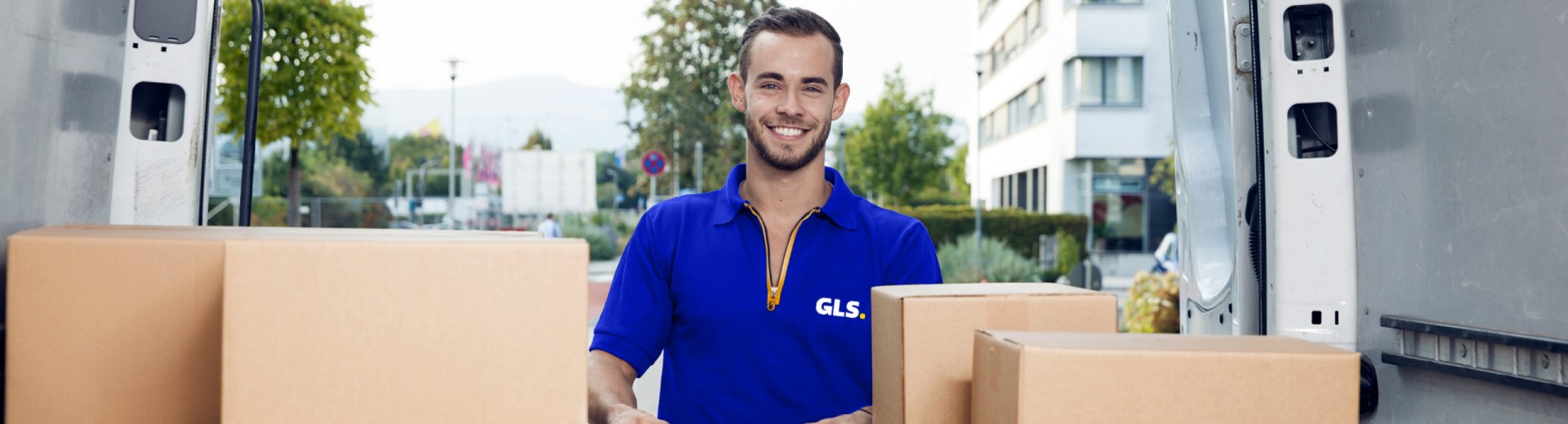 Chauffeur GLS France souriant décharge colis arrière camion
