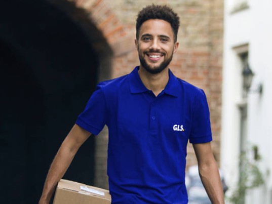 Livreur GLS souriant transportant un colis, illustrant le service Pick&ReturnService pour la gestion optimisée des retours en France et en Europe.