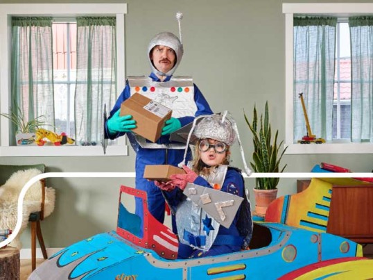 Ein Vater und sein Sohn spielen mit einem Spielzeug aus Pappe