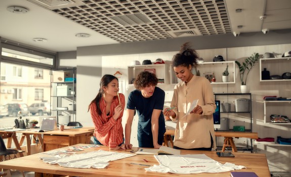 Three people looking at a piece of paper