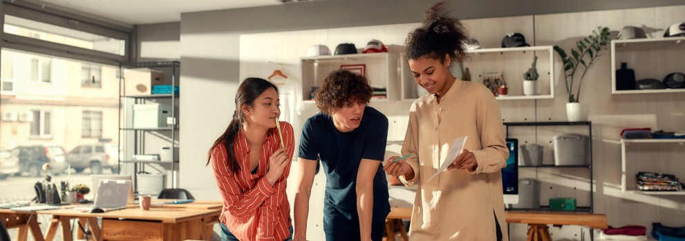 Three people looking at a piece of paper