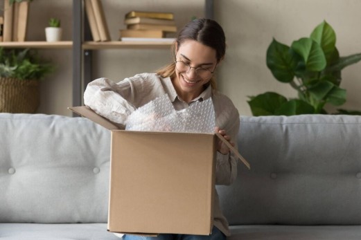 Frau lächelt, als sie durch das GLS-Paket geht