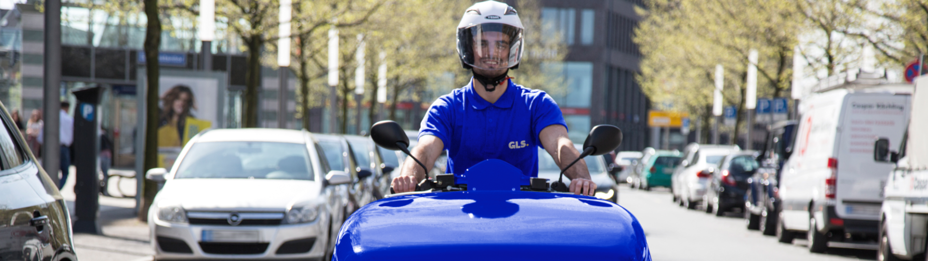 A courier on an e-scooter delivers parcels to customers.
