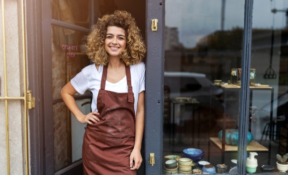 female shop owner smiling in front of her shop