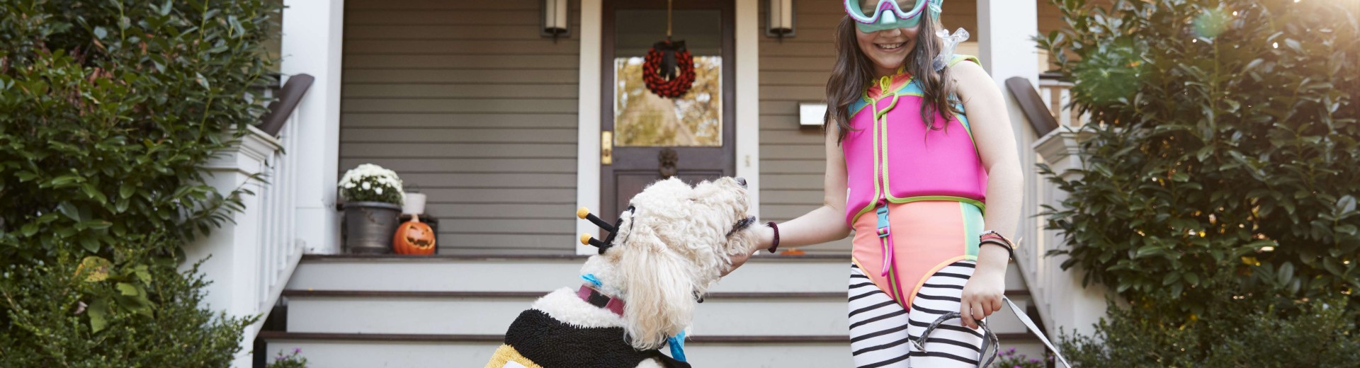 Little girl playing with dog infront of the house