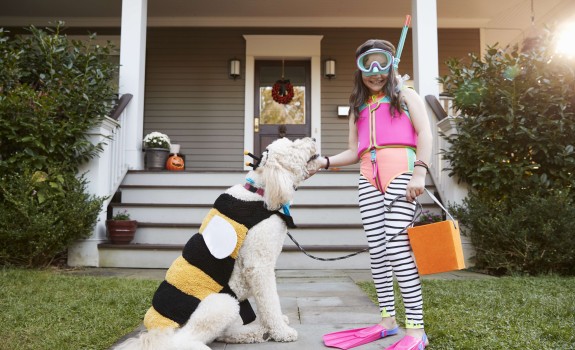 Little girl playing with dog infront of the house